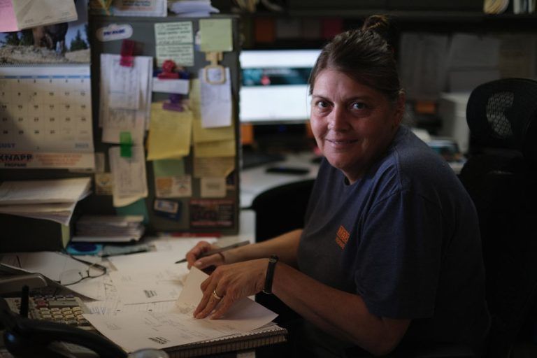 Employee working in an office, managing accounts with paperless billing